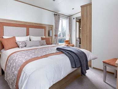 A bedroom with a large bed and window at 2 Bed Lodge Sleeps 4 - Pet Welcome - Fireplace in Cirencester