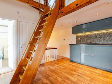 A kitchen with staircase and cabinets at Sedbergh Penthouse - KingBed - Tv - Wifi in Sedbergh