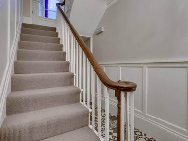 A staircase with carpet and a wooden handrail at Sedbergh Penthouse - KingBed - Tv - Wifi in Sedbergh