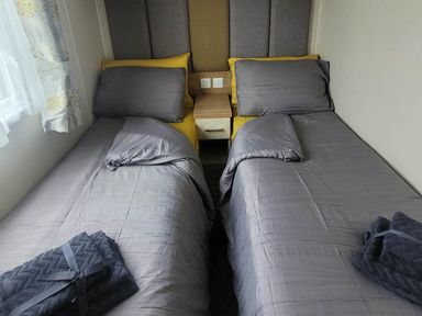 A bedroom with two beds and a bedside table at Beachside Lodge - Sleeps 6 - Pets ok - Parking Heysham