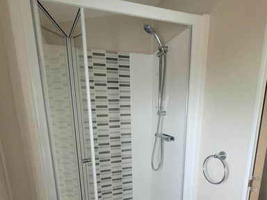 A shower with glass door and wall tiles at Beachside Lodge - Sleeps 6 - Pets ok - Parking Heysham