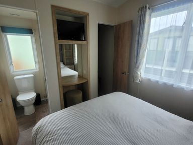 A bedroom with a bed and a toilet in the corner at Beachside Lodge - Sleeps 6 - Pets ok - Parking Heysham