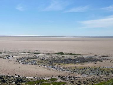 A beach with rocks and tidal water at Beachside Lodge - Sleeps 6 - Pets ok - Parking in Heysham