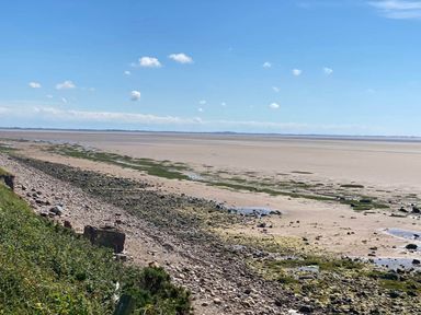 A beach view with rocks and water at Beachside Lodge - Sleeps 6 - Pets ok - Parking Heysham