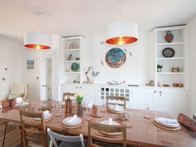 A dining room with a table set for dinner at Lorrell in Salcombe