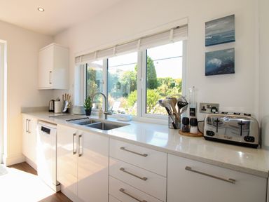 A kitchen with a sink and a dishwasher at Lorrell in Salcombe