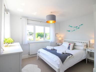 A bedroom with a bed and bedside tables at Lorrell in Salcombe