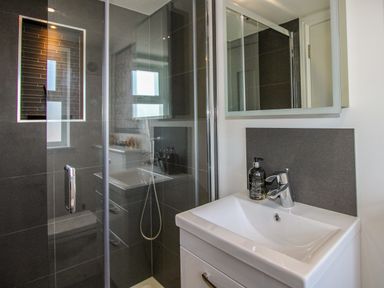 A bathroom with a shower and sink at Lorrell in Salcombe