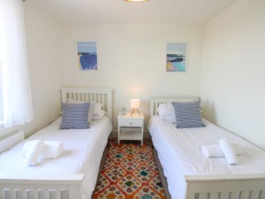 A bedroom with two single beds and a nightstand at Lorrell in Salcombe