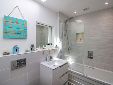 A bathroom with a bathtub and sink at Lorrell in Salcombe