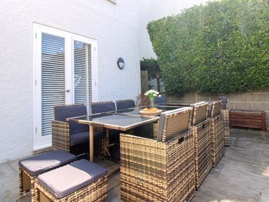 An outdoor dining area with a table and chairs at Lorrell in Salcombe