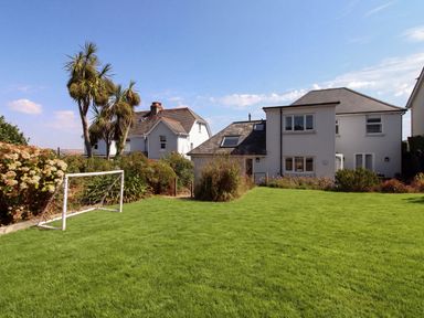 A garden with a goalpost and palm trees at Lorrell in Salcombe