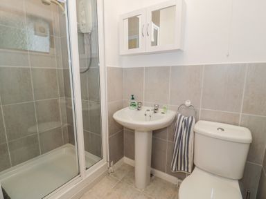 A bathroom with a shower, sink, and toilet at 10 Oakley Wharf Porthmadog
