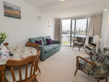 A living room with a sofa and dining table at Harbourside in Porthmadog