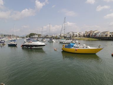 A marina with boats and houses at Harbourside in Porthmadog
