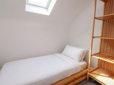 A bedroom with a bed and a shelf at Kiloran in Rhosneigr