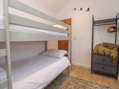 A bedroom with a bunk bed and wardrobe at Kiloran in Rhosneigr