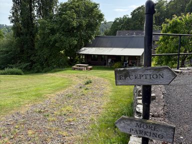 An outdoor area with signposts directing to reception and parking at Walnut Tree Lodge WITH hot tub Presteigne