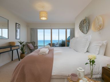 A bedroom with a bed and ocean view at Anchors Rest in St. Ives