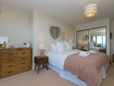 A bedroom with a bed and dresser at Anchors Rest in St. Ives
