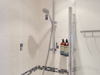 A shower with tiles and toiletries at Anchors Rest in St. Ives
