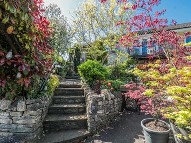 A garden with stone stairs and plants at 7 The Cedars in Wotton-Under-Edge