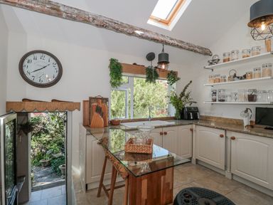 A kitchen with cabinets, sink, and shelving at 7 The Cedars in Wotton-Under-Edge