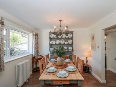 A dining room with a table set for meals at 7 The Cedars in Wotton-Under-Edge