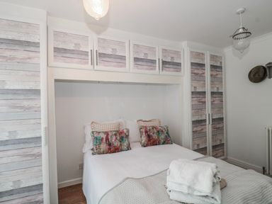 A bedroom with a bed and wardrobe at 7 The Cedars in Wotton-Under-Edge