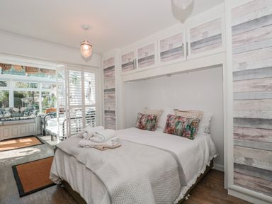 A bedroom with a bed and wall cabinetry at 7 The Cedars in Wotton-Under-Edge