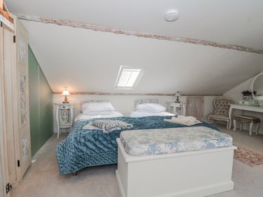 A bedroom with a bed and table at 7 The Cedars in Wotton-Under-Edge