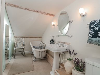 A bathroom with a bathtub and sink at 7 The Cedars Wotton-Under-Edge