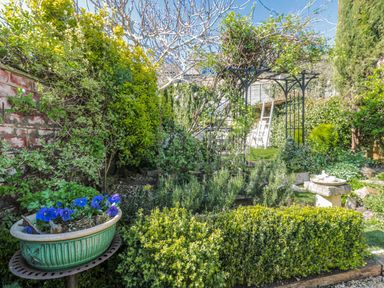 A garden featuring a birdbath and an archway at 7 The Cedars in Wotton-Under-Edge