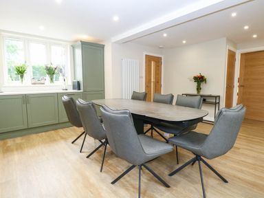 A dining room with a table and chairs at Bramley Cottage in Worlingham