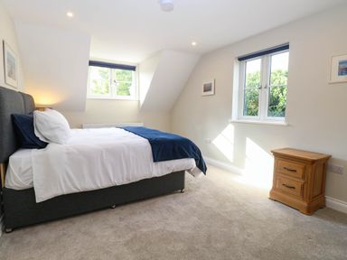 A bedroom with a bed and nightstand at Bramley Cottage in Worlingham