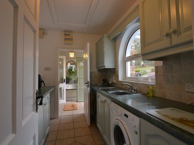 A kitchen with a sink and washing machine at An Grianan Getaway in Burt