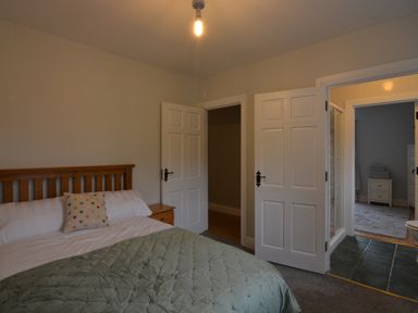 A bedroom with a bed and open doors at An Grianan Getaway in Burt
