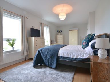 A bedroom with a bed and dresser at An Grianan Getaway, Burt