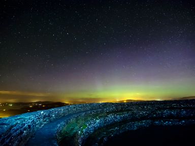 A night sky with stars and distant lights at An Grianan Getaway in Burt