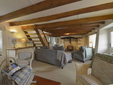 A living room with sofa and fireplace at Mays Cottage in Wadebridge