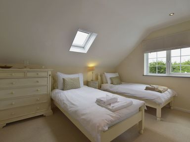 A bedroom with twin beds and a dresser at Mays Cottage in Wadebridge