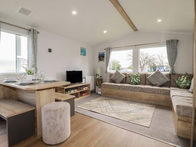 A living room with a dining table and sofa at Shamrocks Cove Caravan