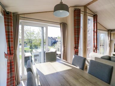 A dining room with a large table and chairs at Borwick Heights 17 in Carnforth