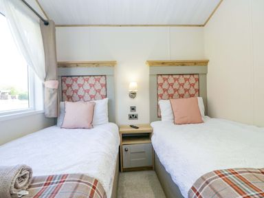 A bedroom with two beds and a bedside table at Borwick Heights 17 Carnforth