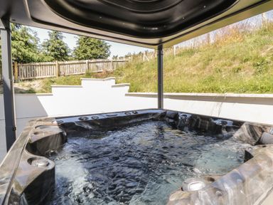 A hot tub with water in an outdoor area at Brynseion Uchaf near Aberystwyth