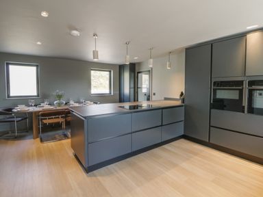 A kitchen featuring an island, cabinets, and dining area at Brynseion Uchaf near Aberystwyth