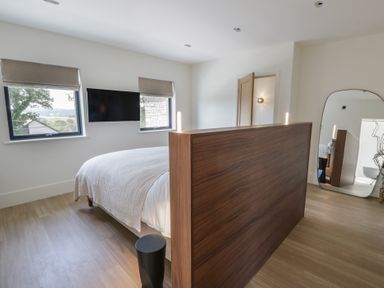 A bedroom with a bed and wooden divider at Brynseion Uchaf near Aberystwyth