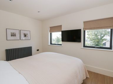 A bedroom with a bed and wall-mounted television at Brynseion Uchaf near Aberystwyth