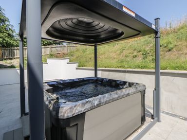A hot tub with a canopy in a garden at Brynseion Uchaf near Aberystwyth