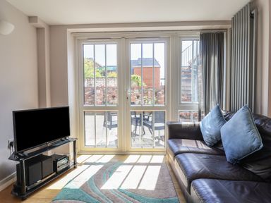 A living room with a TV and a sofa at Beck House in Weymouth